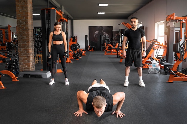 Photo gratuite plein coup de gens qui regardent l'homme au gymnase