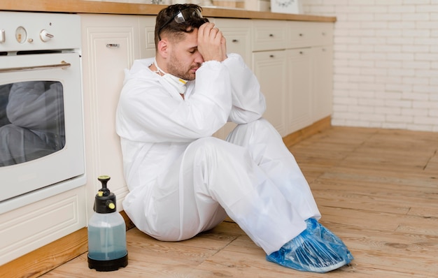 Plein coup homme assis sur le plancher de la cuisine