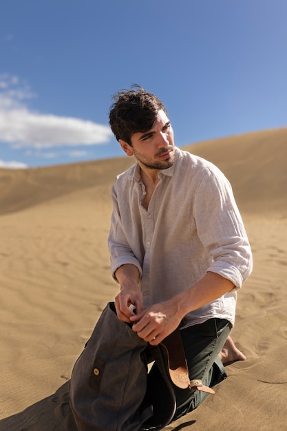 Plein coup homme assis sur le sable