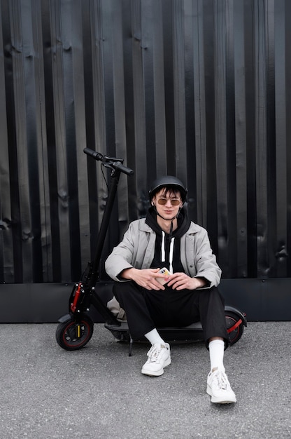 Photo gratuite plein coup homme assis sur un scooter