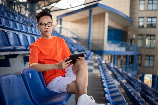 Plein coup homme assis avec tablette