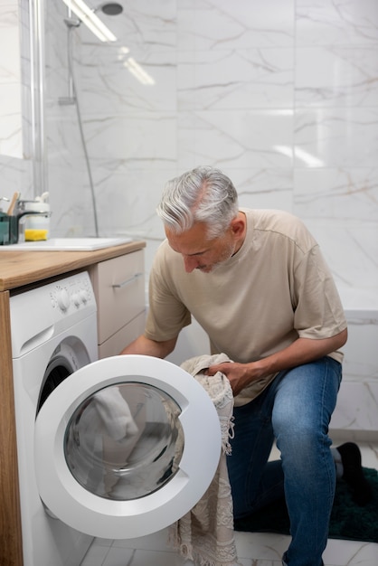 Plein coup homme chargeant la machine à laver