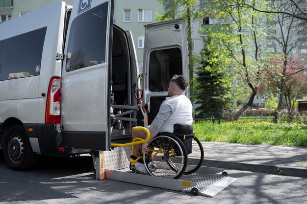 Plein coup d'un homme handicapé qui monte dans la voiture