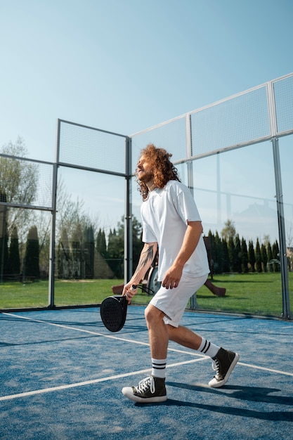 Plein coup homme jouant au paddle-tennis