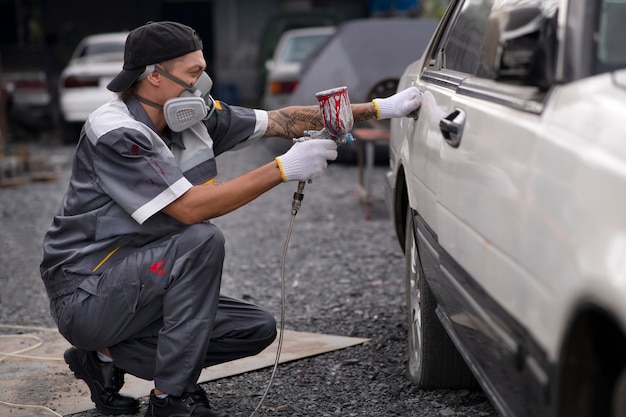 Plein coup homme pulvérisant de la peinture en poudre