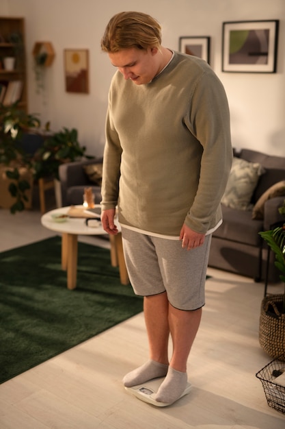 Photo gratuite plein coup d'homme de taille plus debout sur une échelle