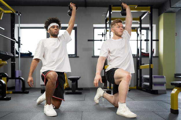 Plein coup d'hommes faisant de l'exercice avec des kettlebells