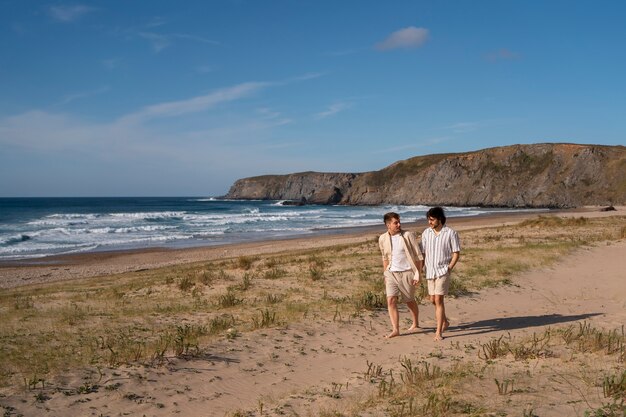 Plein coup d'hommes gais se tenant la main à la plage