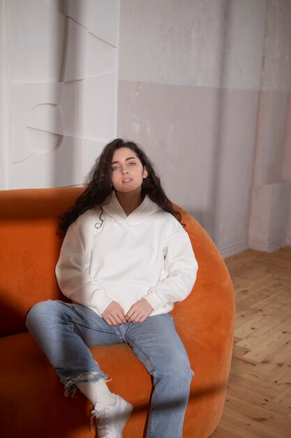 Plein coup jeune femme assise sur un canapé