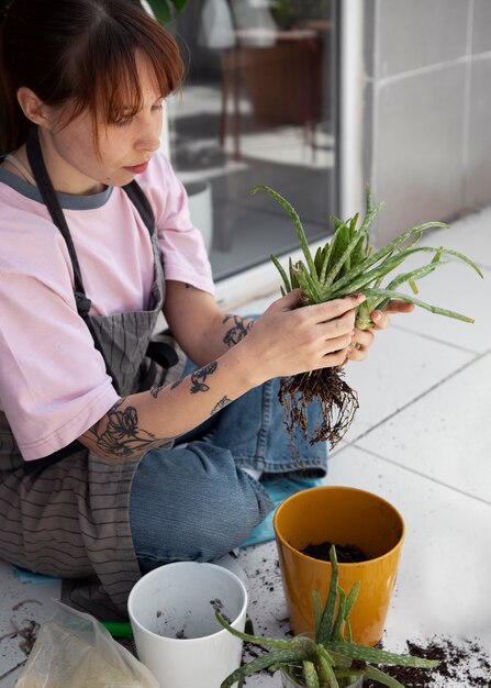 Plein coup jeune femme transplantant une plante