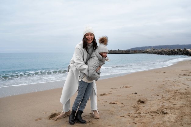 Photo gratuite plein coup mère et enfant à la plage