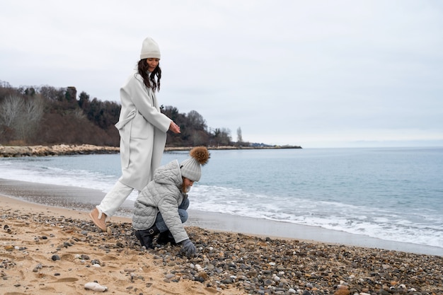 Photo gratuite plein coup mère et enfant à la plage