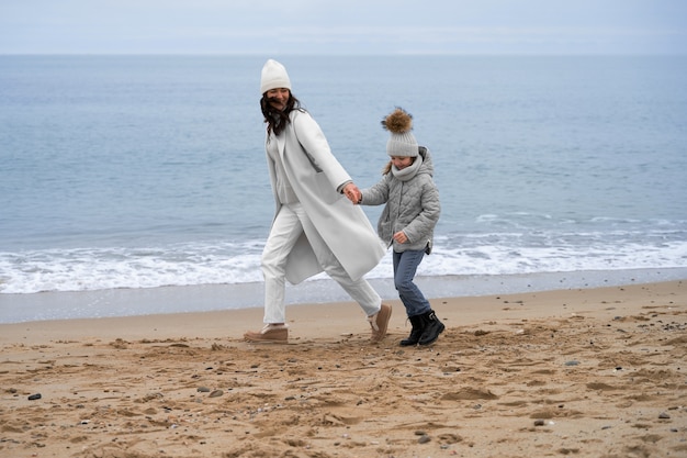 Photo gratuite plein coup mère et enfant à la plage