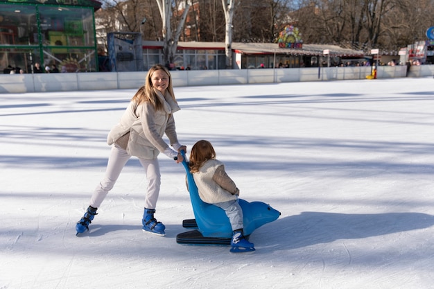 Photo gratuite plein coup mère heureuse avec fille à la patinoire