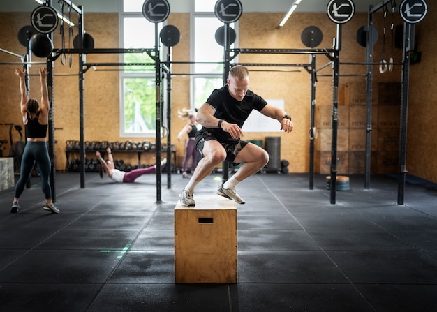 Photo gratuite plein coup de personnes en forme s'entraînant au gymnase