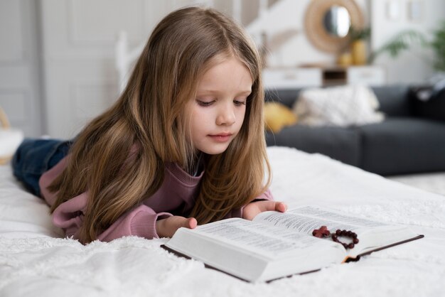 Plein coup petite fille lisant la bible