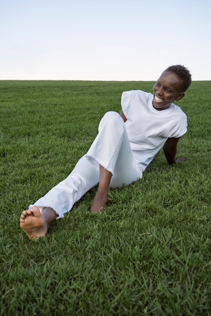 Photo gratuite plein coup smiley femme allongée sur l'herbe