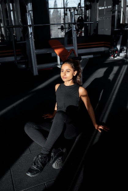 Plein coup smiley femme assise au gymnase