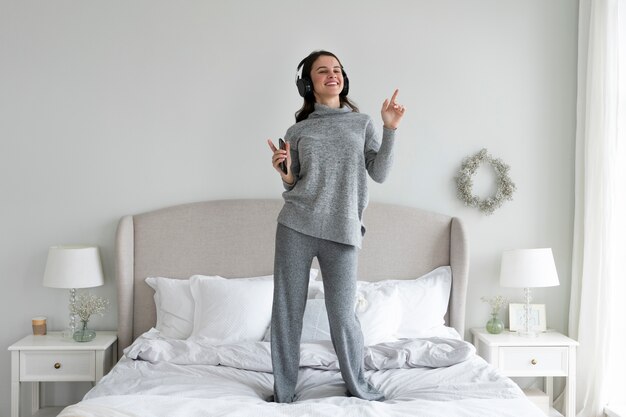 Plein coup smiley femme debout dans son lit