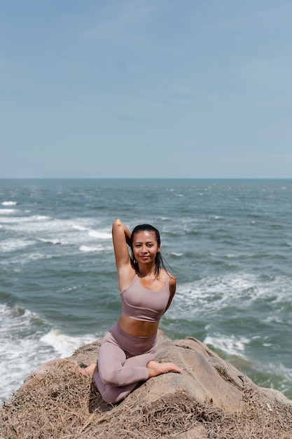 Photo gratuite plein coup smiley femme faisant du yoga dans la nature