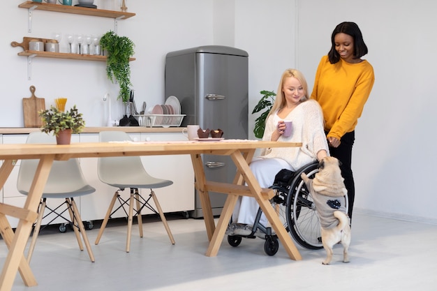 Plein coup smiley femme en fauteuil roulant caresser le chien