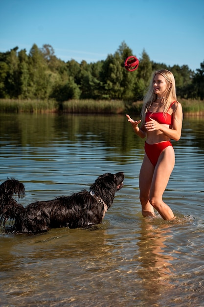 Plein coup smiley femme jouant avec un chien