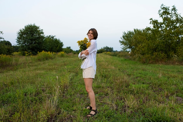 Plein coup smiley femme tenant des fleurs