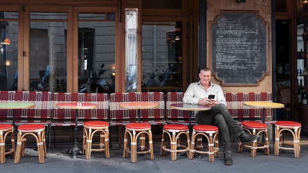 Plein coup smiley homme assis au bistro