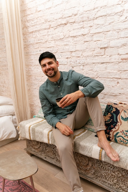 Plein coup smiley homme assis à l'intérieur