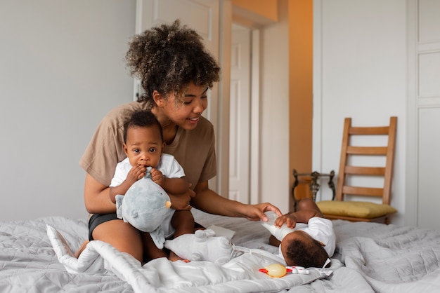 Photo gratuite plein coup smiley mère au lit