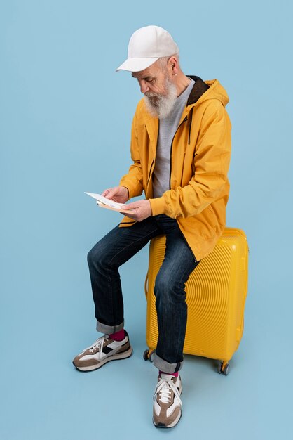 Plein coup vieil homme assis sur des bagages