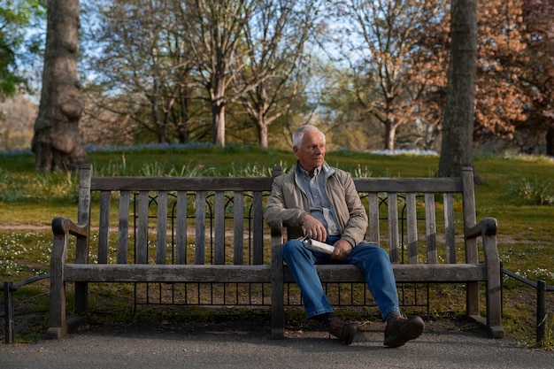 Photo gratuite plein coup vieil homme assis sur un banc