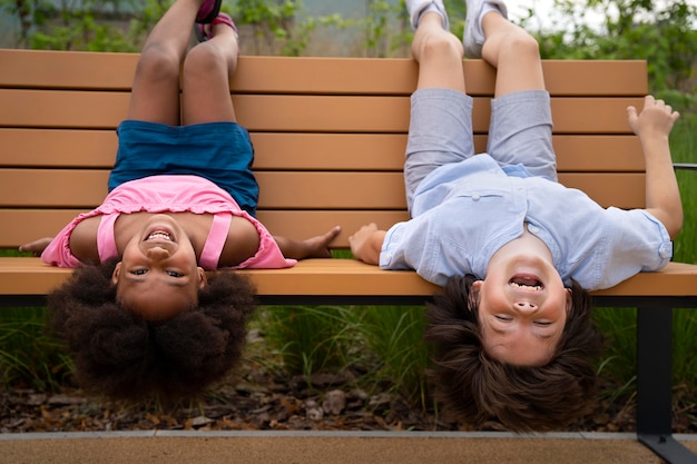 Photo gratuite plein d'enfants allongés sur un banc