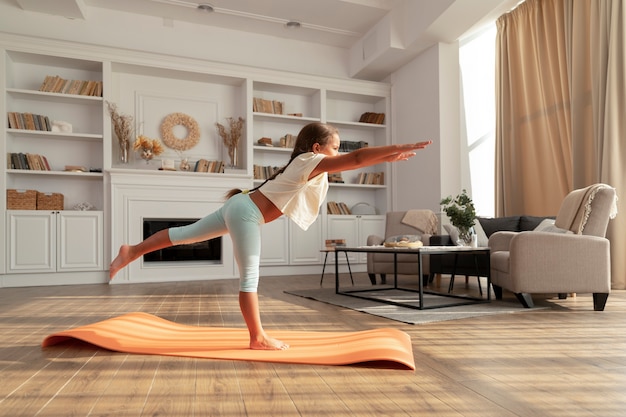 Photo gratuite plein d'enfants faisant du yoga à la maison