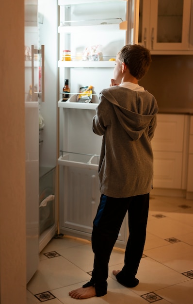 Photo gratuite plein d'enfants regardant dans le réfrigérateur