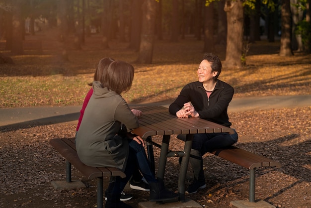 Plein de gens assis sur un banc à l'extérieur