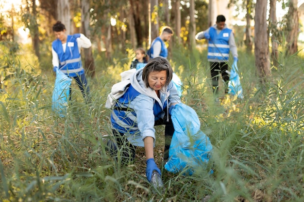 Photo gratuite plein de gens ramassant des ordures