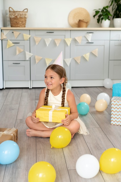 Pleine fille souriante tenant un cadeau