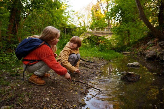 Pleine photo d'enfants explorant la nature ensemble