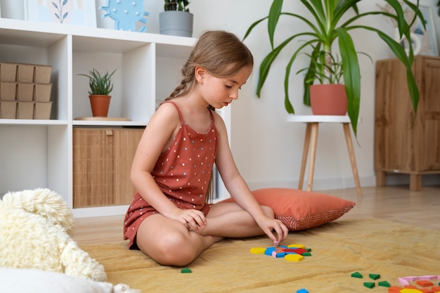 Pleine photo fille faisant un puzzle à la maison