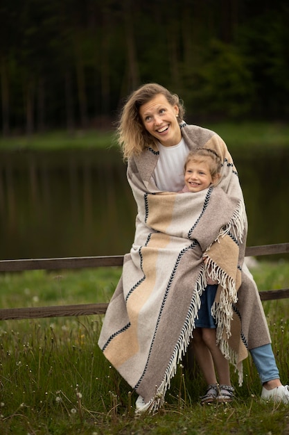 Pleine photo heureuse mère et enfant avec couverture