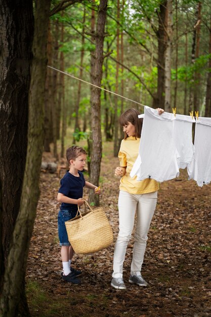 Pleine photo mère et enfant faisant des corvées dans la nature