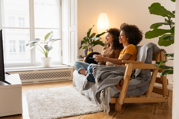 Pleine photo smiley femmes assises sur un canapé