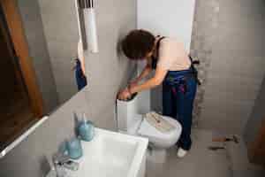Photo gratuite une plombier travaillant pour réparer des problèmes à la maison d'un client.