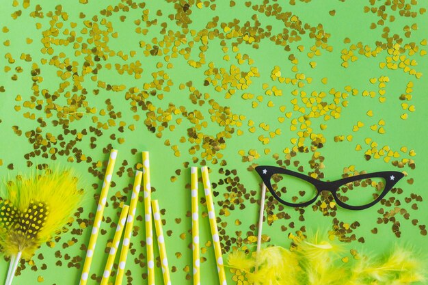 plumes jaunes avec des confettis d&#39;or et lunettes noires