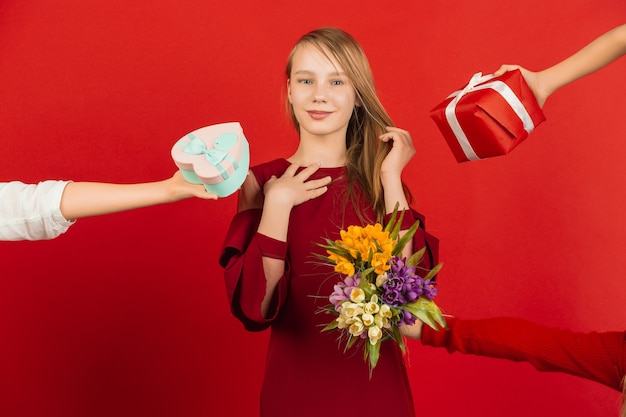 Le plus grand choix. Célébration de la Saint-Valentin. Heureuse, jolie fille caucasienne isolée sur fond de studio rouge. Concept d'émotions humaines, expression faciale, amour, relations, vacances romantiques.