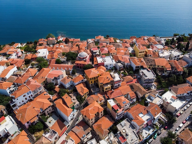 Plusieurs bâtiments aux toits orange, situés sur la côte de la mer Égée