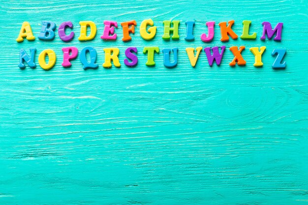 Plusieurs lettres colorées sur table en bois