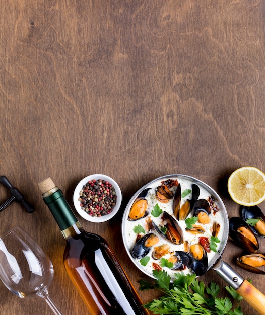 Poêle plate avec des moules en sauce blanche et du vin avec fond