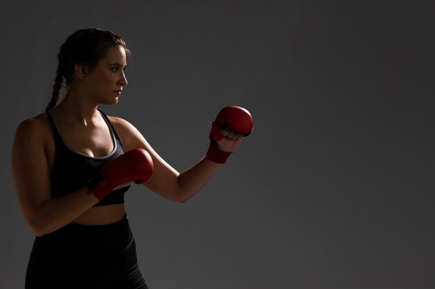 Poinçonnage avec des gants de boxe et un fond sombre